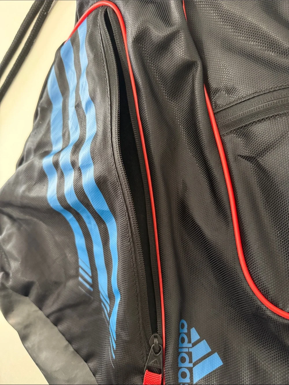 adidas Black Drawstring Backpack with Blue Stripes and Red Accents